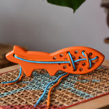 Bajo orange lacing fox wooden toy placed on a rattan stool in the Babipur playroom.