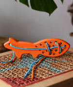 Bajo orange lacing fox wooden toy placed on a rattan stool in the Babipur playroom.