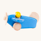 A Bajo blue wooden plane toy with pilot. The blue coloured plane has natural wheels, propeller and tail and a yellow coloured pilot. This plane is part of a wide range of Bajo wooden toy vehicles available at Babipur.