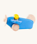 A Bajo blue wooden plane toy with pilot. The blue coloured plane has natural wheels, propeller and tail and a yellow coloured pilot. This plane is part of a wide range of Bajo wooden toy vehicles available at Babipur.