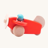A Bajo coral wooden plane toy with pilot. The coral red coloured plane has natural wheels, propeller and tail and a blue coloured pilot. This plane is part of a wide range of Bajo wooden toy vehicles available at Babipur.