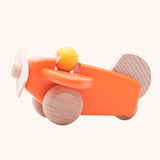 A Bajo orange wooden plane toy with pilot. The orange coloured plane has natural wheels, propeller and tail and a yellow coloured pilot. This plane is part of a wide range of Bajo wooden toy vehicles available at Babipur.