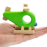 Close up of a Bajo wooden toy helicopter in the palm of a hand