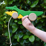 Bajo pull along crocodile wooden toy in a child's hand.