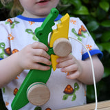 Bajo pull along crocodile wooden toy in a child's hands.