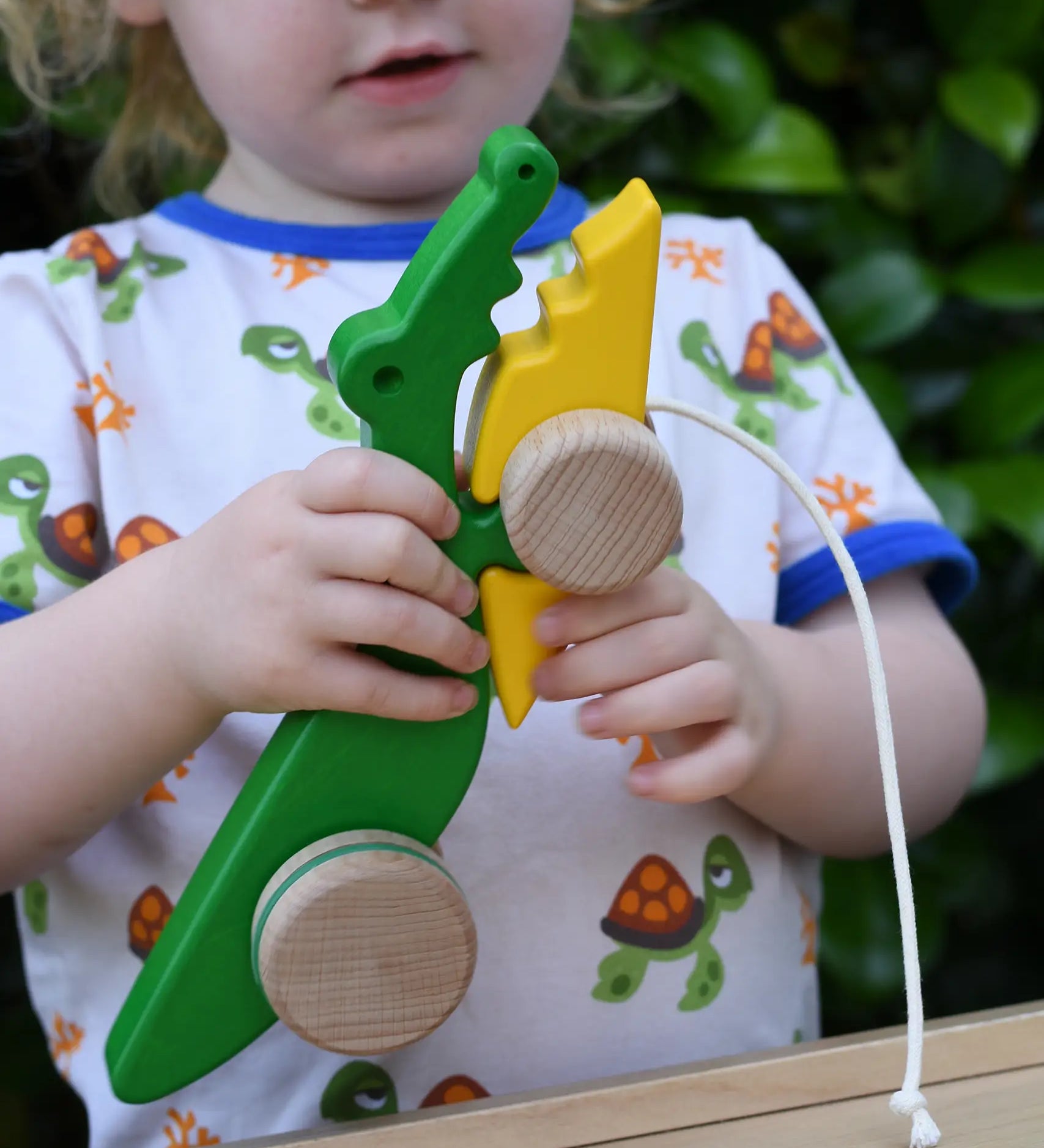 Bajo pull along crocodile wooden toy in a child's hands.