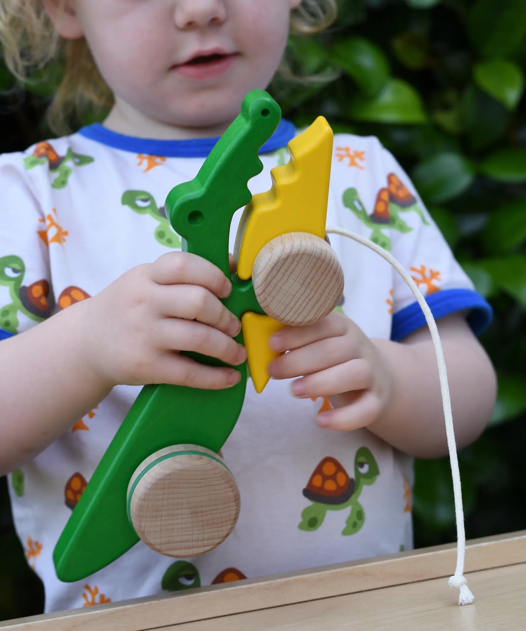 Bajo pull along crocodile wooden toy in a child's hands.