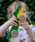 Bajo pull along crocodile wooden toy in a young child's hand.