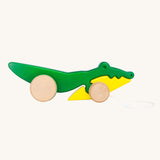 Bajo Pull Along Crocodile wooden toy.  A green and yellow crocodile on natural wooden wheels with a string attached to the front.
These heirloom quality toys by Bajo are part of a wide range of wooden toys available here at Babipur. 