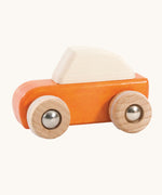 An orange coloured wooden pull back car from Bajo. This wooden car is is part of a wide range of Bajo wooden toy vehicles available at Babipur.
