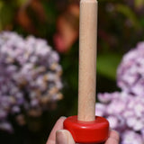 Stacking pole from the Bajo pyramid sorting board and stacker toy in an adult's hand.