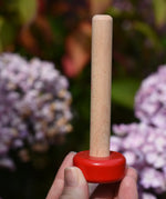 Stacking pole from the Bajo pyramid sorting board and stacker toy in an adult's hand.