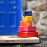 Bajo pyramid sorting board and stacker toy placed on a stone wall with the stacking pole with shapes on placed on the board base.