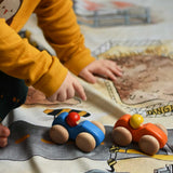 A child playing with the Bajo racing cars that have been placed on a Wonderie building site play cloth. These heirloom quality toys by Bajo are part of a wide range of wooden toys available here at Babipur. 