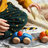 A child playing with the Bajo racing cars that have been placed on a Wonderie building site play cloth. These heirloom quality toys by Bajo are part of a wide range of wooden toys available here at Babipur. 