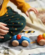 A child playing with the Bajo racing cars that have been placed on a Wonderie building site play cloth. These heirloom quality toys by Bajo are part of a wide range of wooden toys available here at Babipur. 