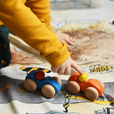 A child playing with the Bajo racing cars that have been placed on a Wonderie building site play cloth. These heirloom quality toys by Bajo are part of a wide range of wooden toys available here at Babipur. 