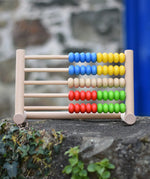 Bajo 50 bead wide abacus placed on a stone wall.