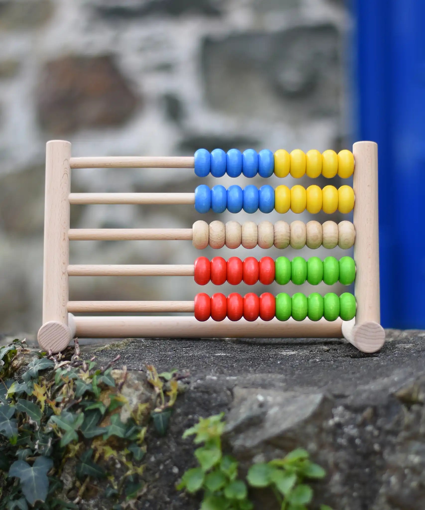 Bajo 50 bead wide abacus placed on a stone wall.