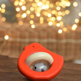 A red coloured Bajo Wooden Bird Baby Rattle with Bell placed on a small wooden table. These heirloom quality toys by Bajo are part of a wide range of wooden toys available here at Babipur. 