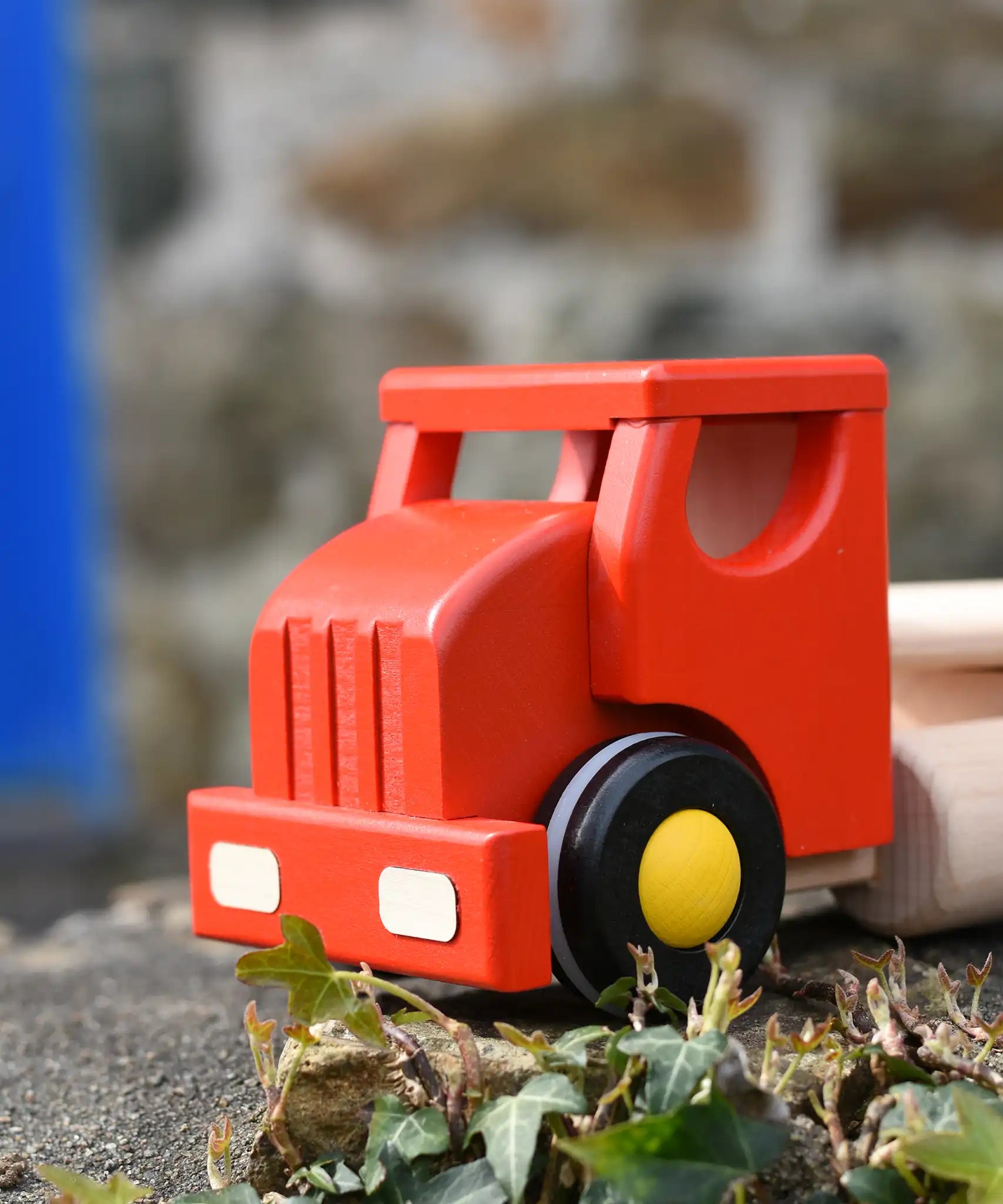 Front of the Bajo large red cargo truck and wooden shape sorter toy.