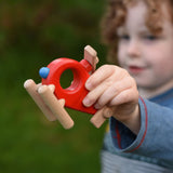 A child playing with the Bajo Red Fire Engine Helicopter wooden toy. The red coloured wooden helicopter has natural propellers and stand and a blue lamp details on the front. These heirloom quality toys by Bajo are part of a wide range of wooden toys available here at Babipur. 