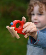 A child playing with the Bajo Red Fire Engine Helicopter wooden toy. The red coloured wooden helicopter has natural propellers and stand and a blue lamp details on the front. These heirloom quality toys by Bajo are part of a wide range of wooden toys available here at Babipur. 