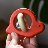 Bajo red snail rattle baby toy in an adult hand.