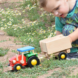 A child playing with the Bajo tractor and trailer outdoors. These heirloom quality toys by Bajo are part of a wide range of wooden toys available here at Babipur.