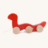 Bajo wooden red wriggly worm, available at Babipur. Body is in two parts that move up and down and features unpainted wooden wheels with a string on the front to pull along