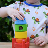 Child placing the top pieces on the Bajo stacking rocket wooden toy.