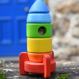 Bajo stacking rocket wooden toy placed on a stone wall. 