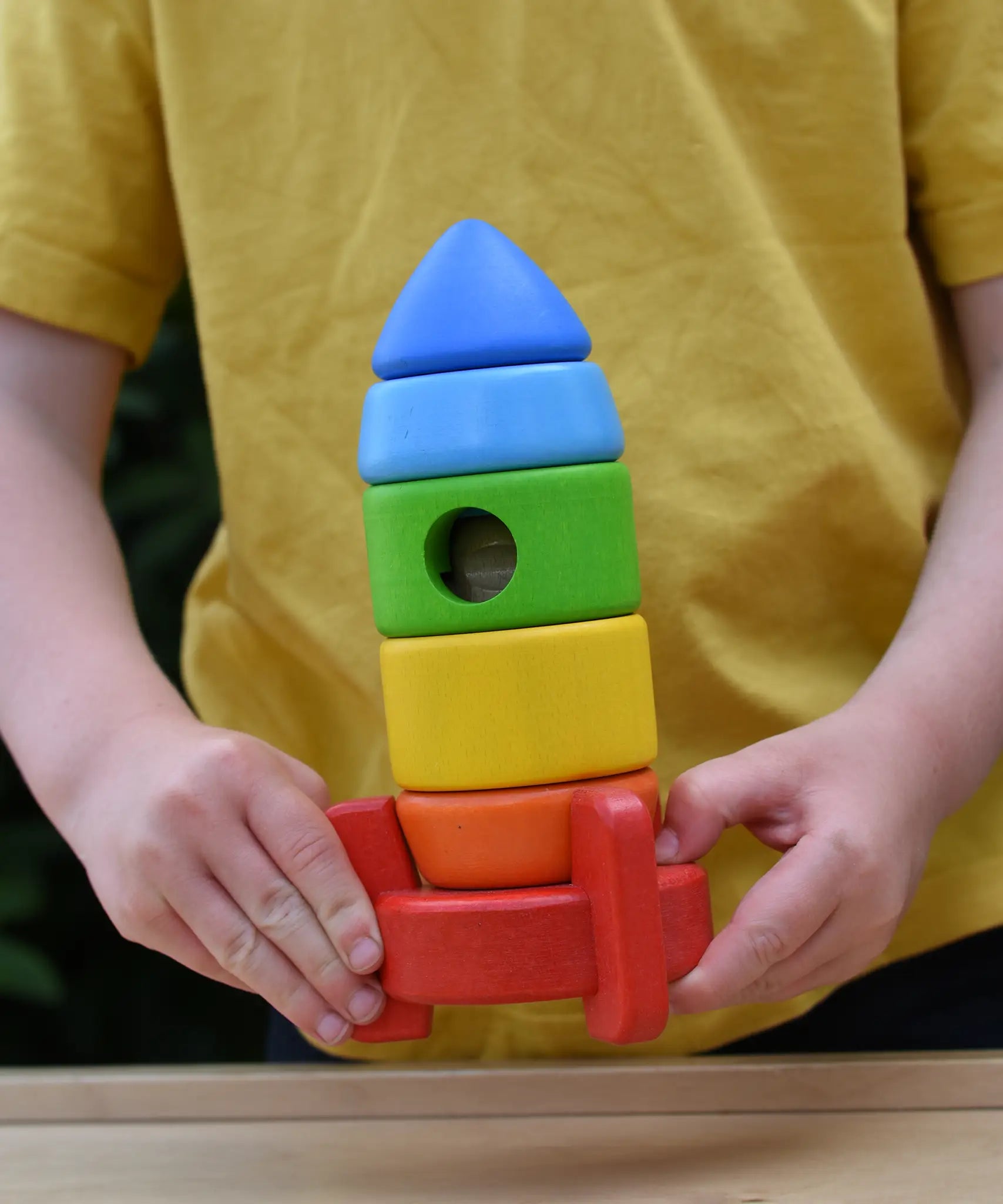 Bajo stacking rocket wooden toy in a child hands.