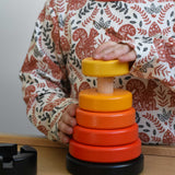 A child playing with a red coloured Bajo wooden rook stacking tower toy. These heirloom quality toys by Bajo are part of a wide range of wooden toys available here at Babipur.