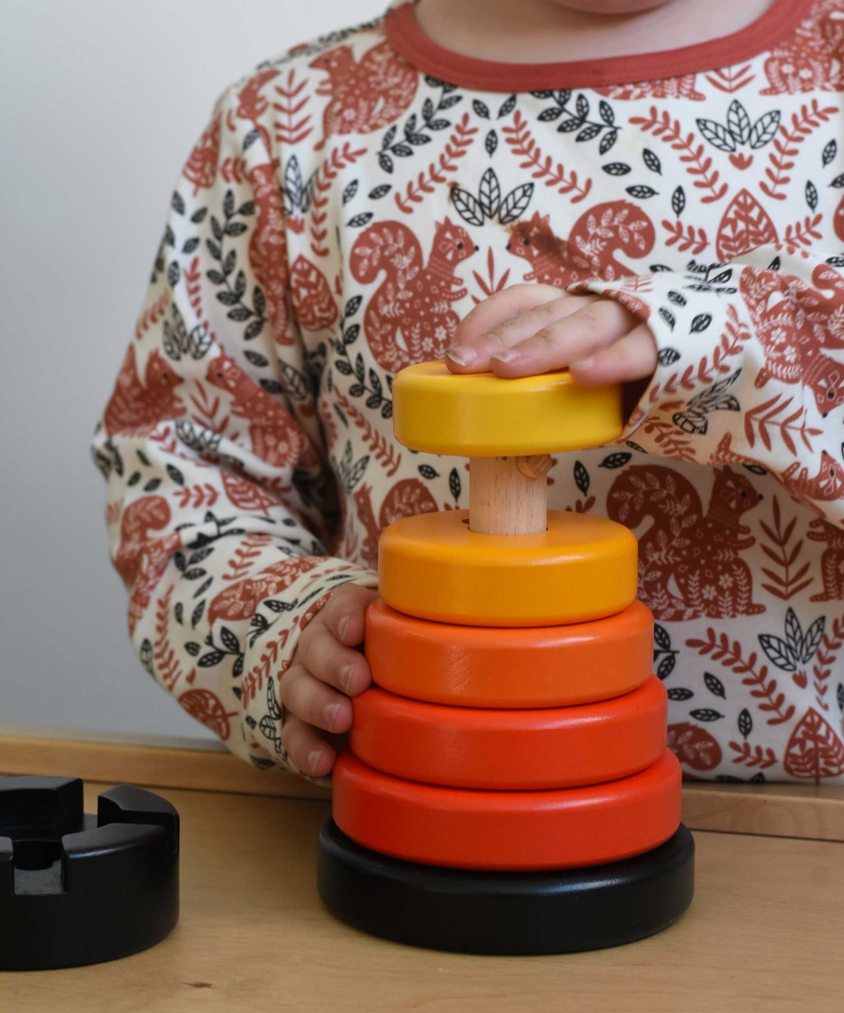 A child playing with a red coloured Bajo wooden rook stacking tower toy. These heirloom quality toys by Bajo are part of a wide range of wooden toys available here at Babipur.