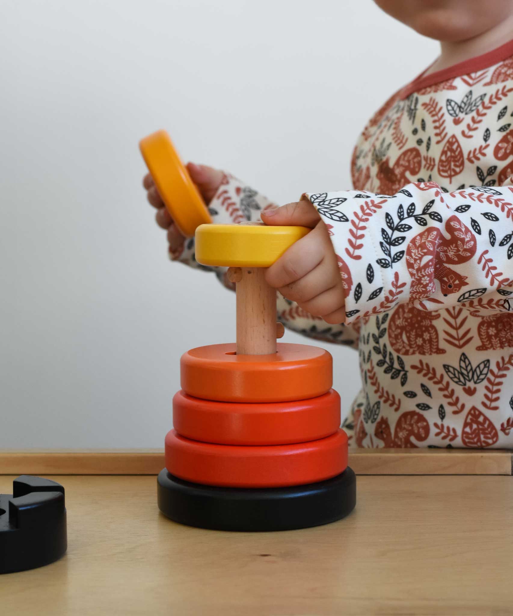 A child playing with a red coloured Bajo wooden rook stacking tower toy. These heirloom quality toys by Bajo are part of a wide range of wooden toys available here at Babipur.