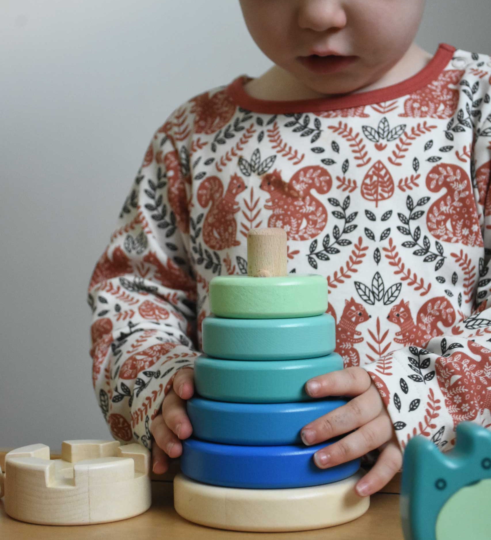 A child playing with a blue coloured Bajo wooden rook stacking tower toy. These heirloom quality toys by Bajo are part of a wide range of wooden toys available here at Babipur.