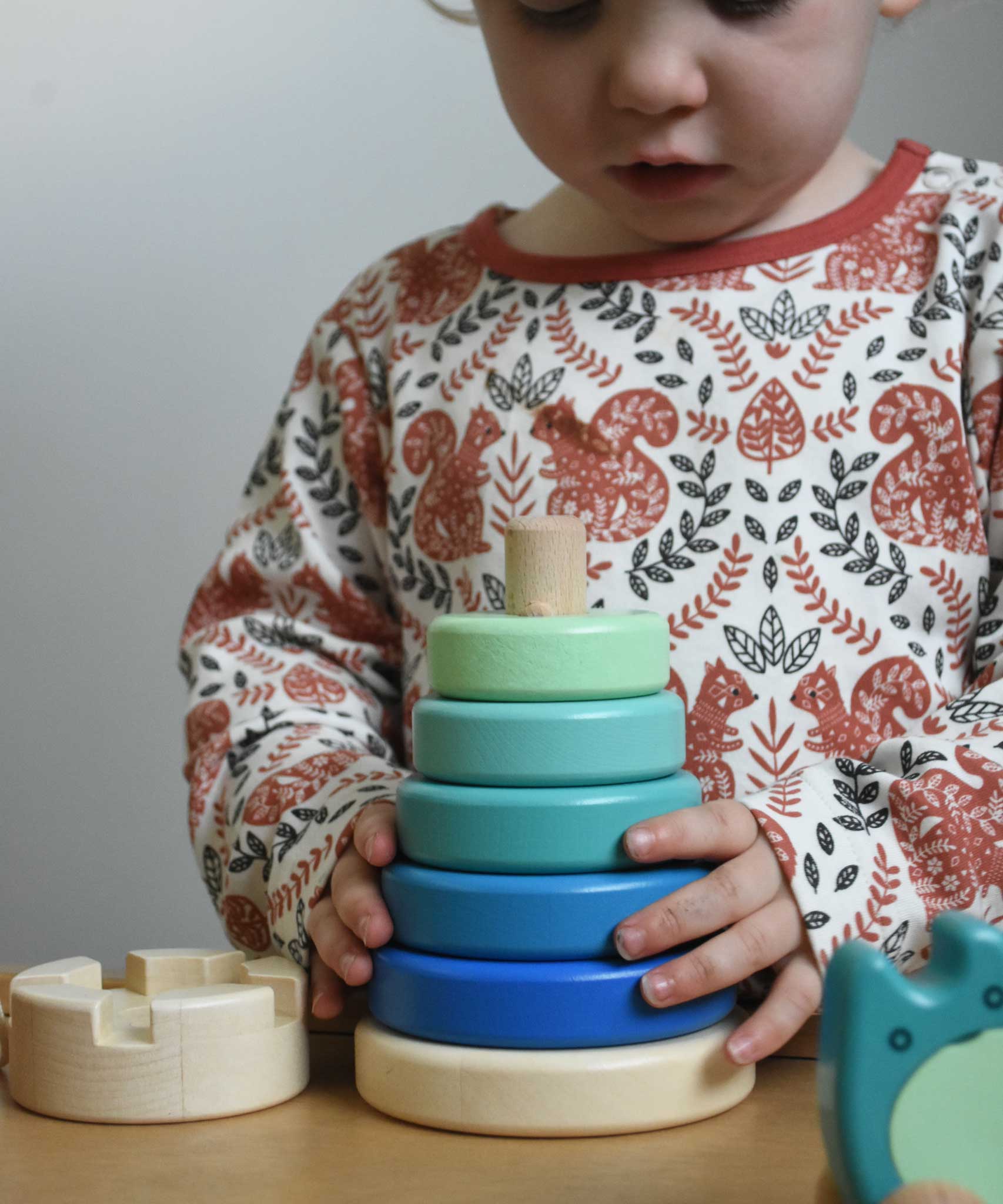 A child playing with a blue coloured Bajo wooden rook stacking tower toy. These heirloom quality toys by Bajo are part of a wide range of wooden toys available here at Babipur.