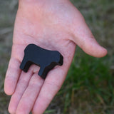 Smallest black sheep piece from the Bajo sheep puzzle in a child's hand.