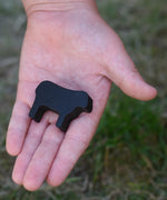 Smallest black sheep piece from the Bajo sheep puzzle in a child's hand.