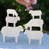 Child stacking the figures from the Bajo sheep puzzle on top of each other.