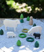 Sheep figures from the Bajo sheep puzzle used in a small world play scene with Grapat mandala pieces and rings as scenery. 