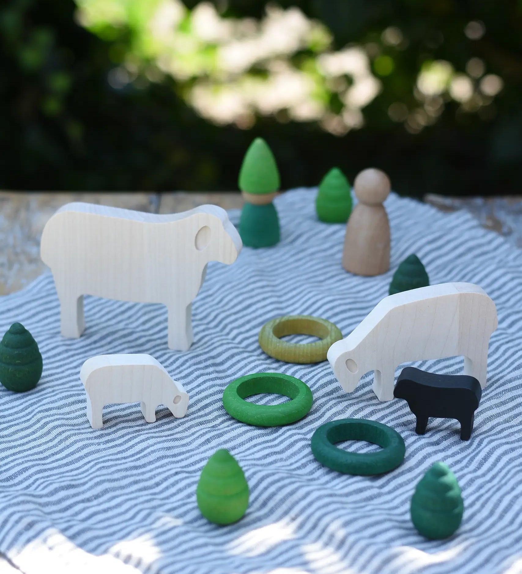 Sheep figures from the Bajo sheep puzzle used in a small world play scene with Grapat mandala pieces and rings as scenery. 