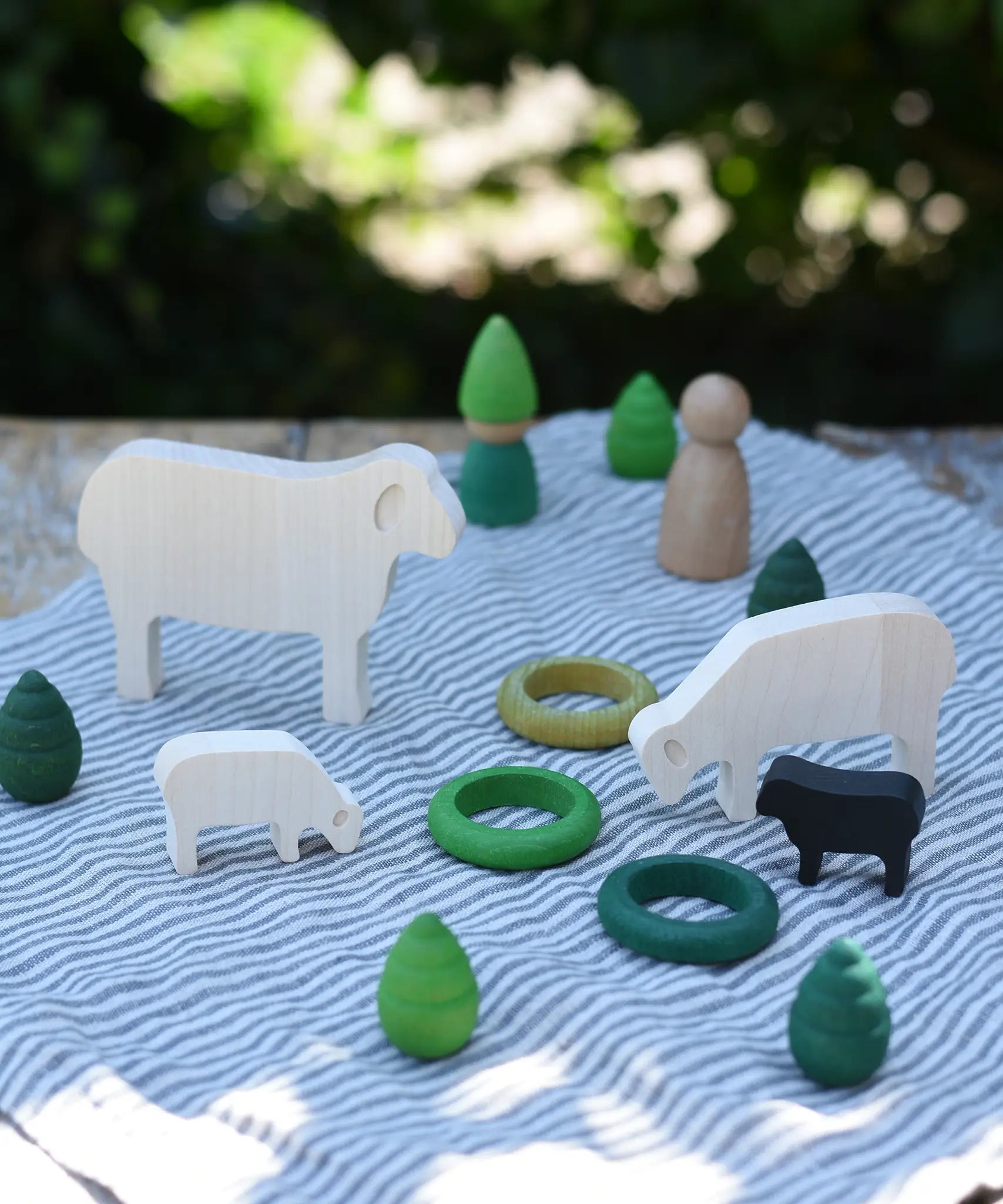Sheep figures from the Bajo sheep puzzle used in a small world play scene with Grapat mandala pieces and rings as scenery. 