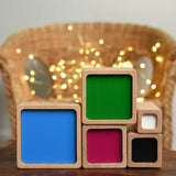 The Bajo Square Pyramid Sensory Wooden Stacking Toy blocks stacked on their side showing the coloured sides. The set contains 5 wooden square and rectangular shaped blocks with a different coloured bases. Each blocks make a different sound when shaken. These heirloom quality toys by Bajo are part of a wide range of wooden toys available here at Babipur. 