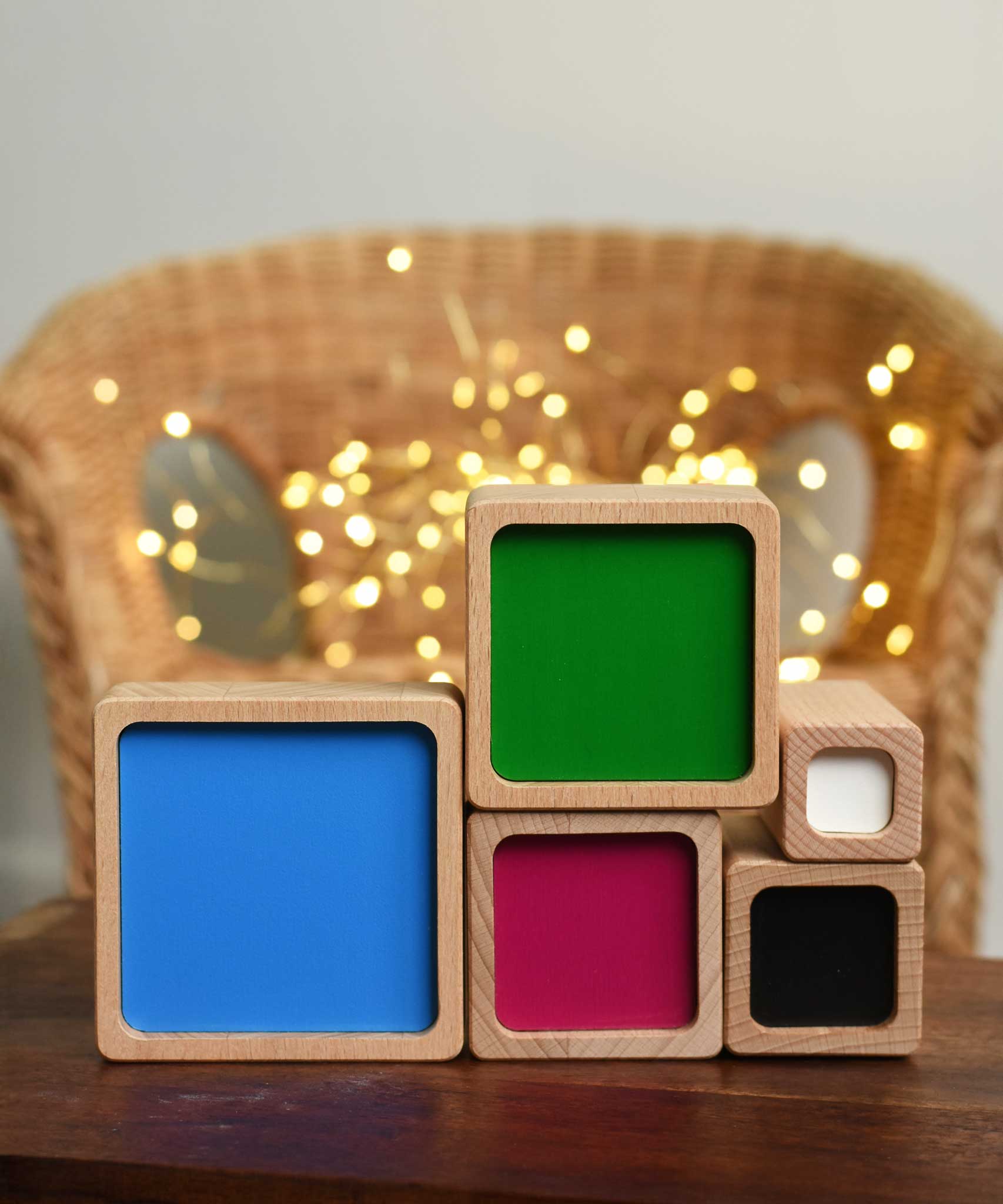 The Bajo Square Pyramid Sensory Wooden Stacking Toy blocks stacked on their side showing the coloured sides. The set contains 5 wooden square and rectangular shaped blocks with a different coloured bases. Each blocks make a different sound when shaken. These heirloom quality toys by Bajo are part of a wide range of wooden toys available here at Babipur. 