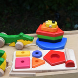 Bajo wooden toys placed on a wooden surface, nemo boat stacker toy, pyramid sorting board and crocodile pull along.