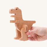 Bajo t-rex dinosaur wooden puzzle and sorter toy. The dinosaur shown in an adult's hand. These heirloom quality toys by Bajo are part of a wide range of wooden toys available here at Babipur. 