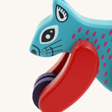A close up of the Bajo x Tobe blue wooden jumping squirrel toy available at Babipur. Showing the cute painted face and wheels on the front 
