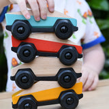 Four Bajo ToBe Poly cars wooden toys stacked up on top of each other.
